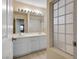 Bathroom featuring double vanity, bright lighting, framed mirror and access to shower/tub at 506 Staghorn Pass Ave, Las Vegas, NV 89183