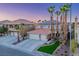 Beautiful two-story home with a tile roof, solar panels, and palm trees at twilight at 506 Staghorn Pass Ave, Las Vegas, NV 89183