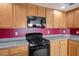 This kitchen features wood cabinets, granite countertops, and stainless steel appliances at 506 Staghorn Pass Ave, Las Vegas, NV 89183