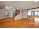 Open-concept living area features hardwood floors, neutral walls, and an elegant wooden staircase at 506 Staghorn Pass Ave, Las Vegas, NV 89183