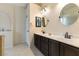 Bathroom with a dual sink vanity, tile floors, and a round mirror at 5107 Morning Splash Ave, Las Vegas, NV 89131