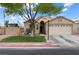 Inviting single-level home with a two-car garage and a front yard featuring lush green grass and mature tree at 5107 Morning Splash Ave, Las Vegas, NV 89131