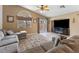 Comfortable living room with a large couch, ceiling fan, and sliding door to backyard at 5107 Morning Splash Ave, Las Vegas, NV 89131