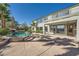 Expansive backyard featuring a pool with a waterfall, an outdoor patio, lush greenery and mature landscaping at 5337 Polizze Ave, Las Vegas, NV 89141