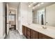 Bathroom featuring double sinks, large mirror, and separate doorway to a shower and another bedroom at 5337 Polizze Ave, Las Vegas, NV 89141