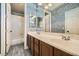 Bathroom features a double sink vanity, decorative wallpaper, large mirror, and shower and bathtub combo at 5337 Polizze Ave, Las Vegas, NV 89141