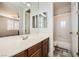 Bathroom featuring double sinks, large mirror, and a doorway leading to a shower and bathtub combo at 5337 Polizze Ave, Las Vegas, NV 89141