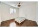 Bedroom with hardwood floors, a window with plantation shutters, and a twin sized bed on a grey rug at 5337 Polizze Ave, Las Vegas, NV 89141
