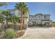 Beautiful two-story home with a three-car garage, stone accents, and lush palm trees at 5337 Polizze Ave, Las Vegas, NV 89141