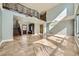 Bright and spacious living room with soaring ceilings, travertine flooring, and a wrought iron staircase at 5337 Polizze Ave, Las Vegas, NV 89141