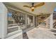 Covered outdoor patio with ceiling fans, a stone fireplace, and views of the lush backyard and landscaping at 5337 Polizze Ave, Las Vegas, NV 89141