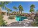 Backyard pool featuring mature palm trees, stone waterfall feature, and adjacent spa at 5337 Polizze Ave, Las Vegas, NV 89141