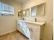 Bright bathroom featuring a double sink vanity with white cabinets and modern fixtures at 5384 Hanging Tree Ln, Las Vegas, NV 89118