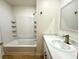 Bright bathroom featuring a bath tub with a shower and a single sink vanity at 5384 Hanging Tree Ln, Las Vegas, NV 89118