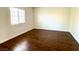This bedroom has hardwood floors, neutral colored walls, and a window at 5384 Hanging Tree Ln, Las Vegas, NV 89118
