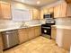 Bright kitchen featuring wood cabinets, stainless steel appliances, and tile flooring at 5384 Hanging Tree Ln, Las Vegas, NV 89118