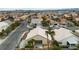 This aerial view captures houses, palm trees, and streets within this desert community landscape at 5513 Oakview Falls Ct, Las Vegas, NV 89148