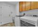 Well-lit laundry room with modern washer and dryer and cabinets at 5513 Oakview Falls Ct, Las Vegas, NV 89148