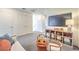 Bright bonus room boasts cozy seating, sleek media console, and plush carpeted flooring, creating a perfect relaxation space at 6157 Aster Garden St # 153, North Las Vegas, NV 89081