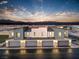 Modern townhome exterior featuring attached garages, neutral tones, and mountain views at sunset at 6157 Aster Garden St # 153, North Las Vegas, NV 89081