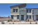 Stylish townhome exterior featuring two-tone facade, modern windows, and manicured front yard at 6157 Aster Garden St # 153, North Las Vegas, NV 89081