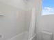 Bathroom featuring bathtub with white tile surround, shower curtain, and a window at 6545 Vanhoven Crest St, Las Vegas, NV 89166