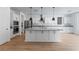 Open kitchen with a large island, modern white cabinets, and stainless steel appliances offers a functional and stylish space at 6545 Vanhoven Crest St, Las Vegas, NV 89166
