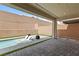 A modern backyard oasis featuring a sleek pool with built-in sun loungers and an elegant stone patio at 6545 Vanhoven Crest St, Las Vegas, NV 89166