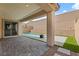 Relaxing backyard featuring a covered patio and refreshing in-ground pool with artificial turf accents at 6545 Vanhoven Crest St, Las Vegas, NV 89166