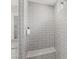 Close-up of a modern shower featuring gray subway tiles, a built-in bench, and glass enclosure at 6545 Vanhoven Crest St, Las Vegas, NV 89166
