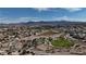 Expansive aerial view of the community featuring a park, surrounding homes, and mountain range in the distance at 703 Flaming Cliffs Ct, Henderson, NV 89014