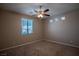 Bedroom with ceiling fan, carpeted floors, and a bright window at 703 Flaming Cliffs Ct, Henderson, NV 89014