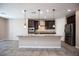 Kitchen features an island with granite countertops and dark cabinets at 703 Flaming Cliffs Ct, Henderson, NV 89014