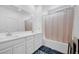 Bright bathroom featuring a bathtub with shower, a double sink vanity with white cabinets and tile floors at 7364 N Decatur Blvd # 4, Las Vegas, NV 89131