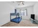Bright bedroom features carpeted floors, a ceiling fan, and a bunk bed with blue bedding and a TV on a stand at 7364 N Decatur Blvd # 4, Las Vegas, NV 89131