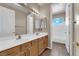 Bathroom with double sink vanity, wooden cabinets, and a separate toilet and bath area at 7715 Villa De La Paz Ave, Las Vegas, NV 89131