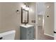 Bathroom with grey vanity, stylish mirror, lighting and door to hall at 7715 Villa De La Paz Ave, Las Vegas, NV 89131