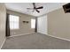 Bedroom featuring neutral colors, carpet, a ceiling fan, and windows with black curtains at 7715 Villa De La Paz Ave, Las Vegas, NV 89131