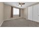 Bedroom features neutral carpeting, a ceiling fan, large window, and double-door closet at 7715 Villa De La Paz Ave, Las Vegas, NV 89131