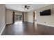Spacious bedroom featuring dark wood floors, ceiling fan, and sliding glass door leading to a balcony at 7715 Villa De La Paz Ave, Las Vegas, NV 89131