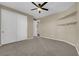 Spacious bedroom featuring carpet, a ceiling fan, and a closet for ample storage at 7715 Villa De La Paz Ave, Las Vegas, NV 89131