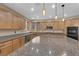 This well-lit kitchen features stainless steel appliances, an island, granite counters, and wooden cabinets at 7715 Villa De La Paz Ave, Las Vegas, NV 89131