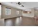 Bright living room featuring wood-look flooring, ceiling fan and connecting archway to the kitchen at 7715 Villa De La Paz Ave, Las Vegas, NV 89131