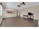 Spacious living room with wood-look floors, ceiling fan, and open archway to the kitchen at 7715 Villa De La Paz Ave, Las Vegas, NV 89131