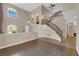 Bright, open living room with soaring ceilings, wood floors, a chandelier, and a staircase at 7715 Villa De La Paz Ave, Las Vegas, NV 89131