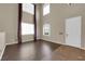 Bright living room with soaring ceilings, wood floors, and large windows by front door at 7715 Villa De La Paz Ave, Las Vegas, NV 89131