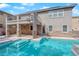 Gorgeous backyard features a sparkling pool with tanning ledge, covered patio, and lush landscaping at 7715 Villa De La Paz Ave, Las Vegas, NV 89131