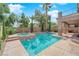 Backyard pool and spa combo featuring stone accents, a covered patio, and mature landscaping at 7715 Villa De La Paz Ave, Las Vegas, NV 89131