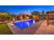 Inviting pool area with a basketball hoop, waterfall feature, mature trees, and manicured landscaping, ideal for Gathering fun at 8429 Brackenfield Ave, Las Vegas, NV 89178