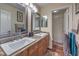 Bathroom with dual sinks, wood cabinets, granite counters and wood flooring at 8429 Brackenfield Ave, Las Vegas, NV 89178